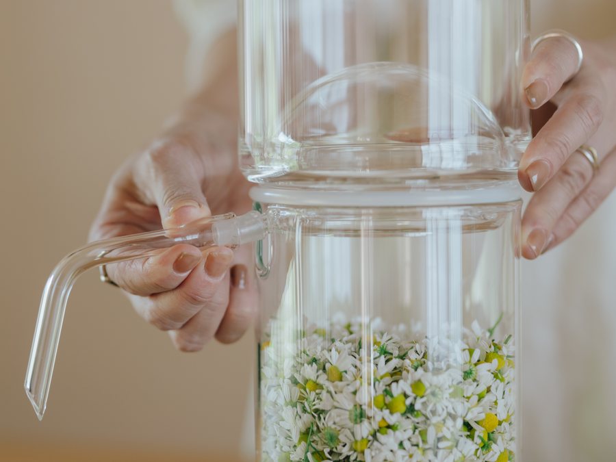 ガラスの蒸留器を組み立てる手元